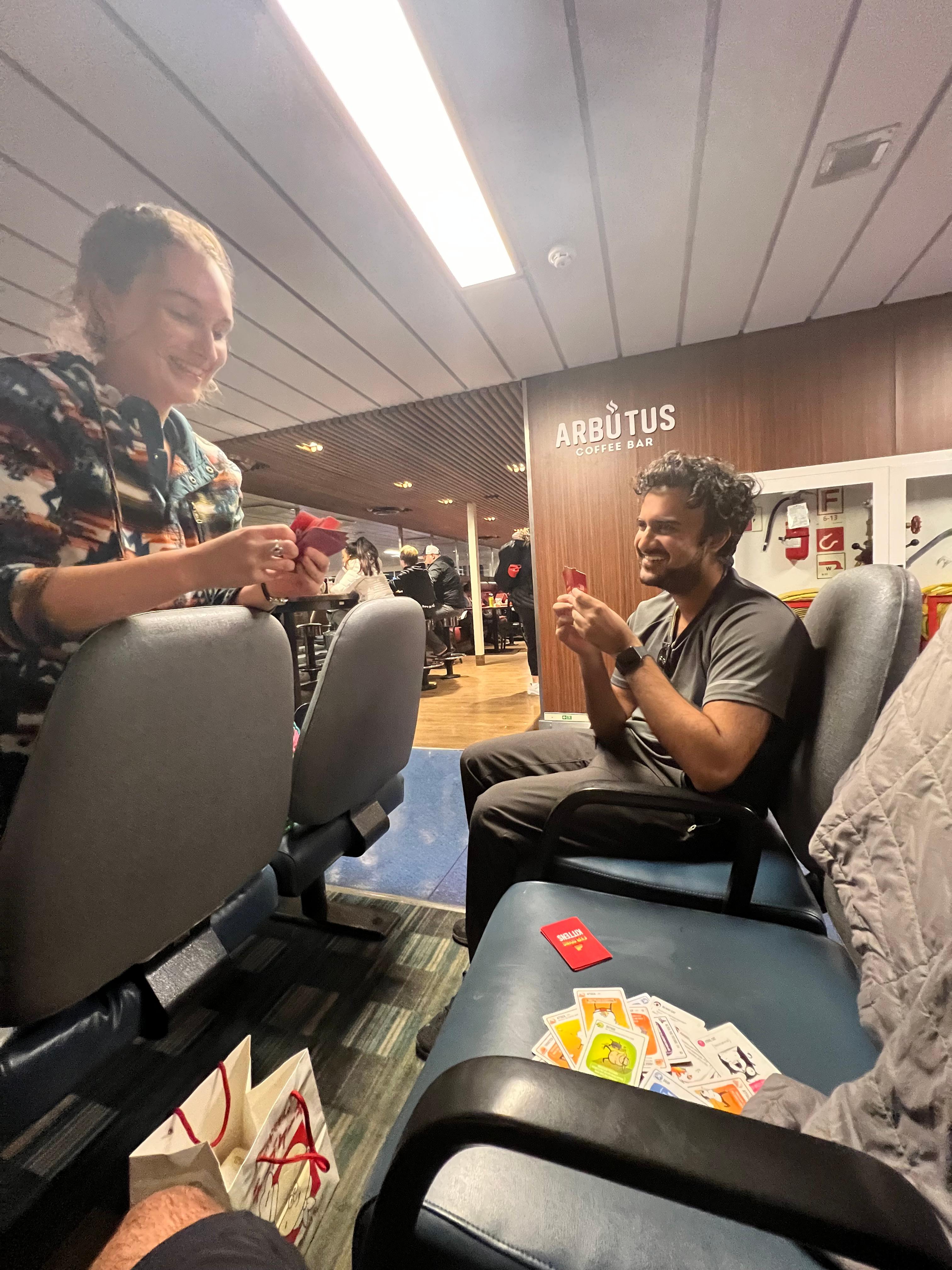 Friends playing Exploding Kittens on a ferry